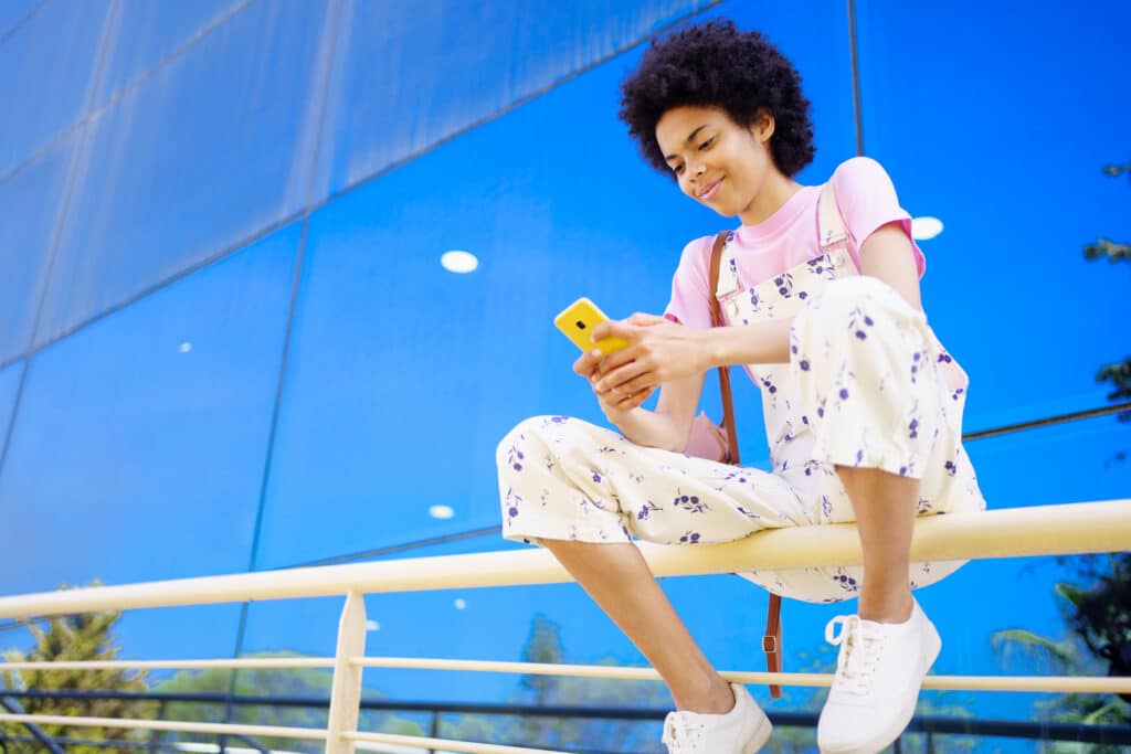 young woman looking contentedly at her phone - Struggling to get found on search engines? This guide reveals proven content strategies to dramatically boost your website's SEO and online visibility. - Content Is King: Crafting Quality Content for Optimal SEO Impact. - your wp guy